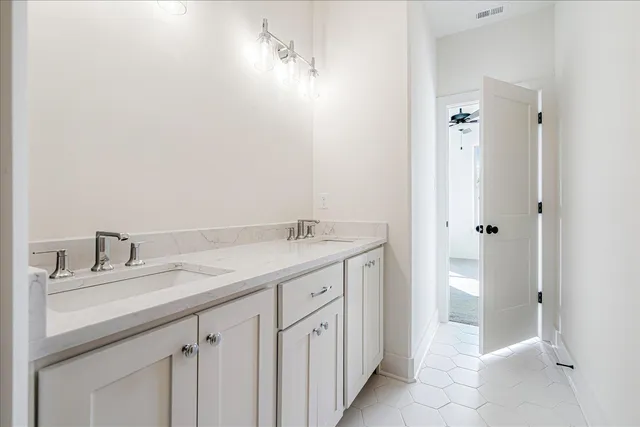 a bathroom with a granite countertop sink two mirror and a