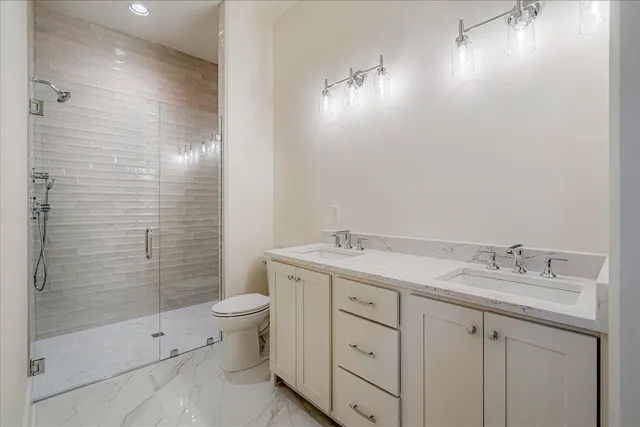 a bathroom with a double vanity sink toilet and shower