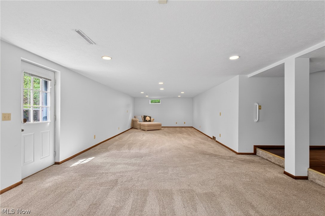 5346 Burlawn Street Northwest Canton, OH 44708 - Photo 25 of 40 Expansive carpeted area with recessed lighting, a windowed egress door, and a window providing natural light