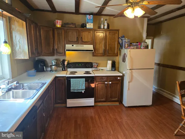 a kitchen with stainless steel appliances a refrigerator sink and wooden floor