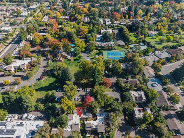 an aerial view of residential houses with outdoor space and trees