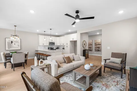 a kitchen with stainless steel appliances granite countertop a sink a stove a refrigerator and white cabinets with wooden floor