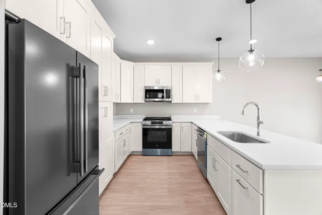 a kitchen with kitchen island a white cabinets and refrigerator