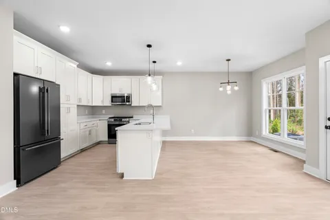 a kitchen with stainless steel appliances kitchen island a sink and a refrigerator