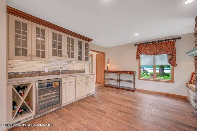 a view of a roof deck with table and chairs a barbeque with wooden floor and fence