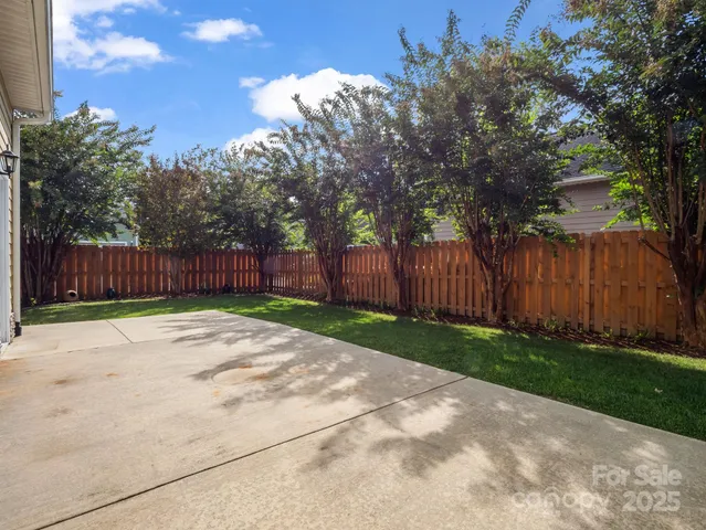 a view of a yard with wooden fence