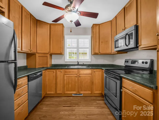 a kitchen with stainless steel appliances granite countertop a stove a sink and a refrigerator