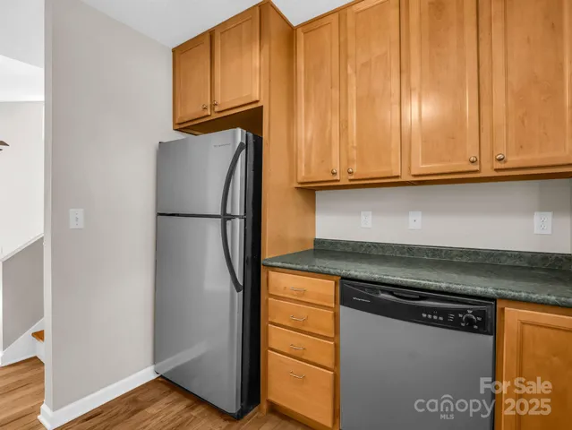 a kitchen with granite countertop cabinets and refrigerator