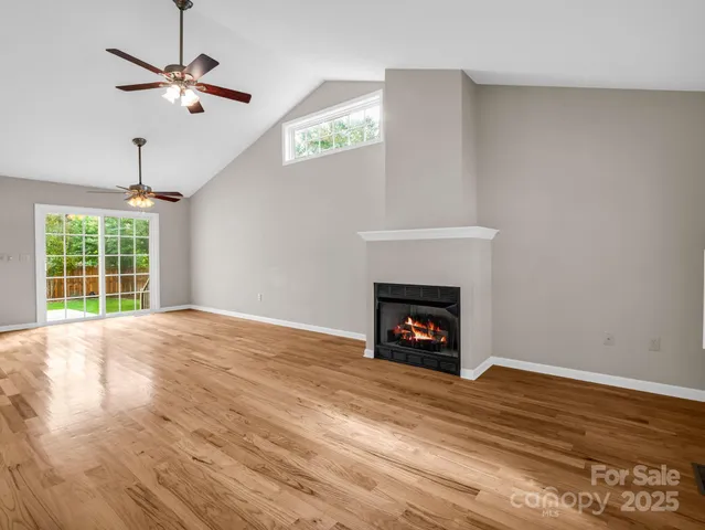 a view of an empty room with a fireplace and a window