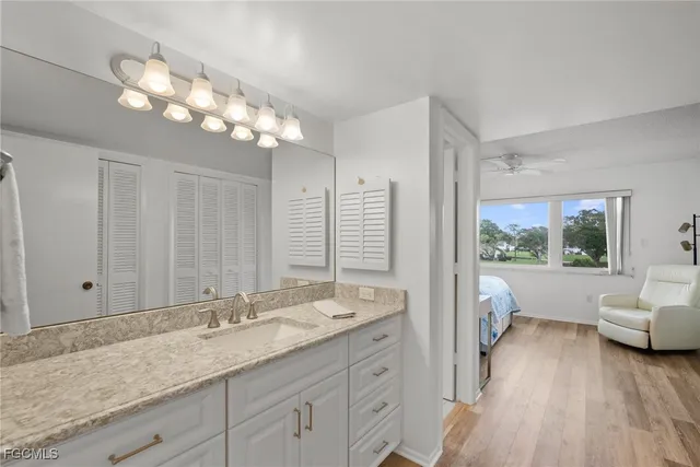 a bathroom with a granite countertop sink a large mirror and a bathtub