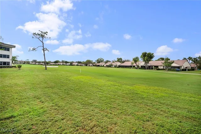 a view of a big building with big yard and big trees