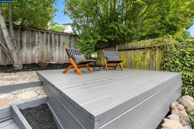 a patio with table and chairs and potted plants