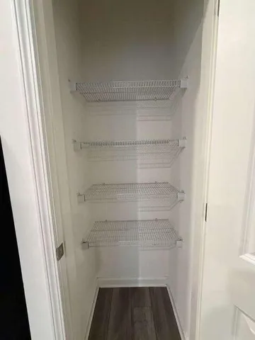 a view of walk in closet with empty racks