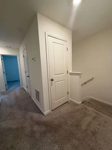 an empty room with white cabinet and mirrors