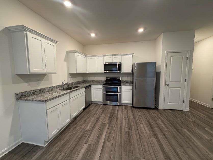 35300 Condor Court Atlanta, GA 30331 - Photo 10 of 31 a kitchen with a refrigerator a stove top oven and wooden floors