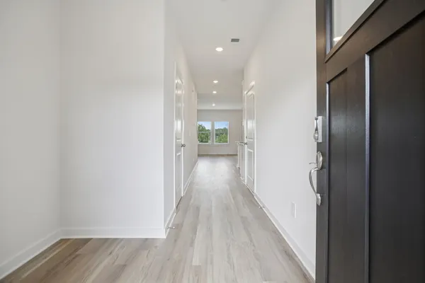 a view of a hallway with wooden floor