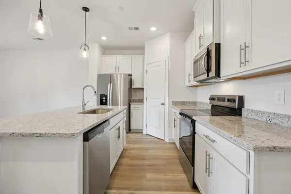 a kitchen with stainless steel appliances granite countertop a sink stove and refrigerator