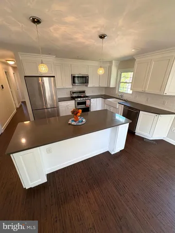 a view of an empty room with kitchen view