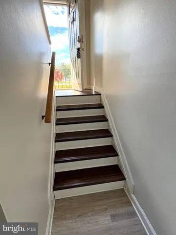 an empty room with wooden floor chandelier fan and windows