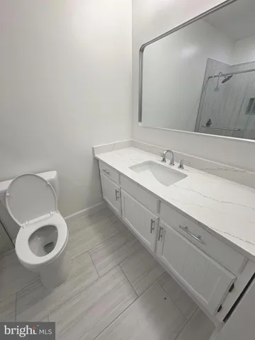 a bathroom with a sink a toilet and a mirror
