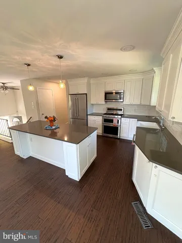 a kitchen with a sink a counter space appliances and cabinets