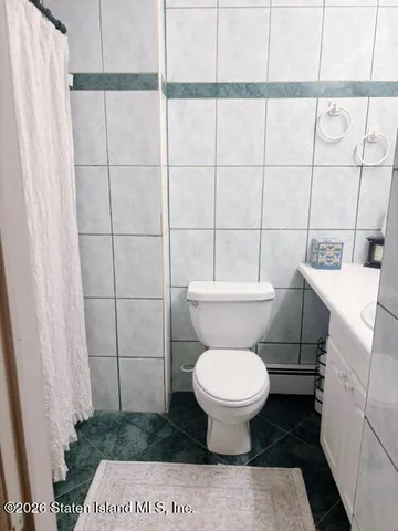 a white toilet sitting next to a white sink and vanity