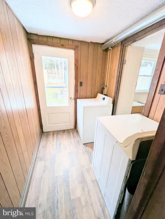 a view of a kitchen with fridge and wooden floor