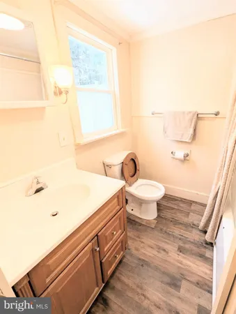 a bathroom with a sink a toilet and a window