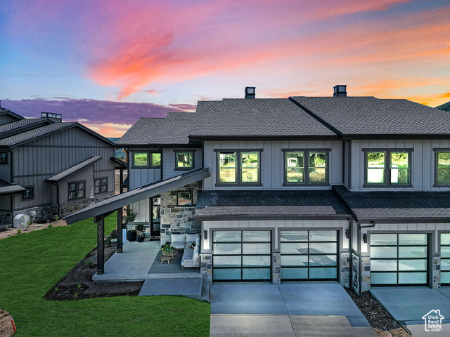 9512 North Bergtop Loop, Unit 184 Heber City, UT 84032 - Photo 1 of 1 Back of house at dusk with stone siding, a garage, board and batten siding, driveway, and a shingled roof