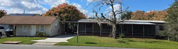 a view of a house with a yard and tree s