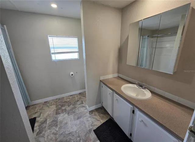 a bathroom with a granite countertop sink and a mirror