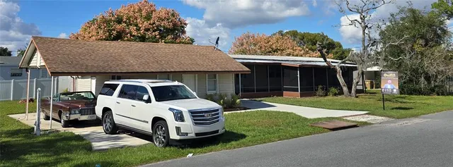 a front view of a house with a garden and trees
