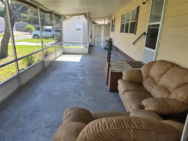 a living room with furniture and a floor to ceiling window
