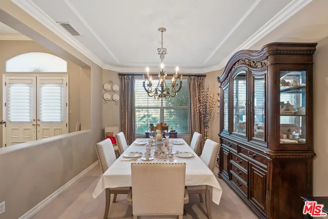 a dining room with furniture a chandelier and wooden floor