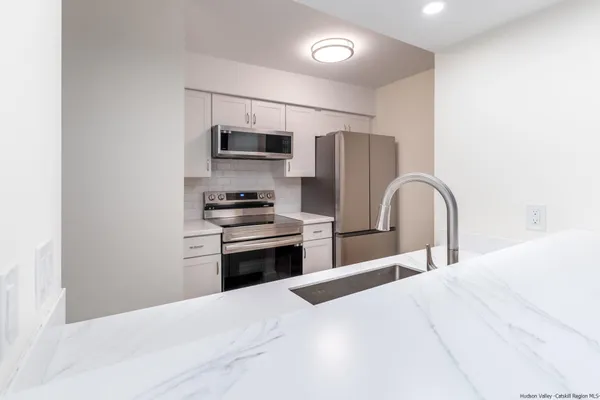 a kitchen with stainless steel appliances kitchen island a refrigerator and a stove top oven