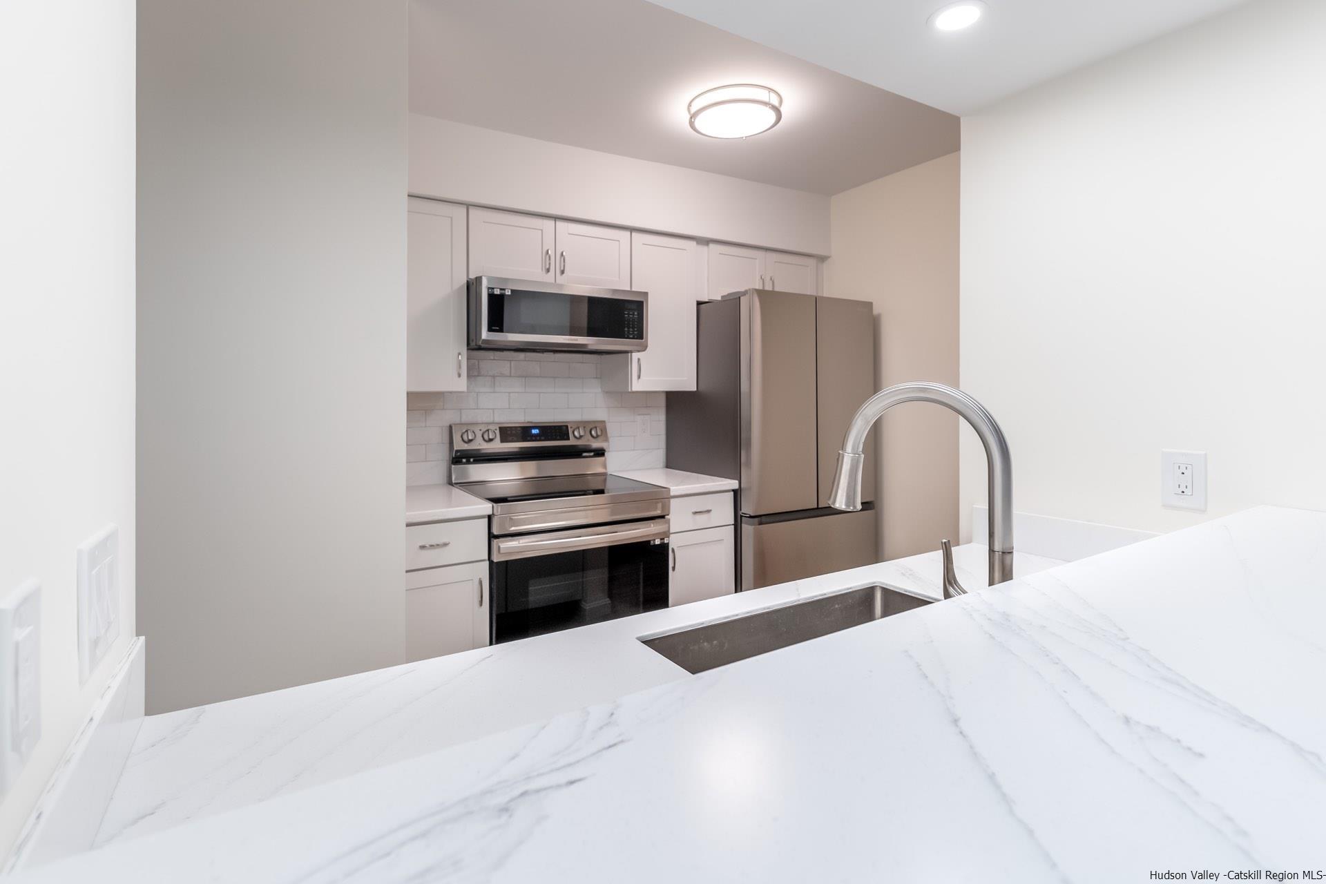 4 Tiger Maple Lane Saugerties, NY 12477 - Photo 13 of 35 a kitchen with stainless steel appliances kitchen island a refrigerator and a stove top oven