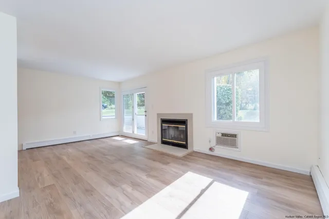 an empty room with windows and fireplace