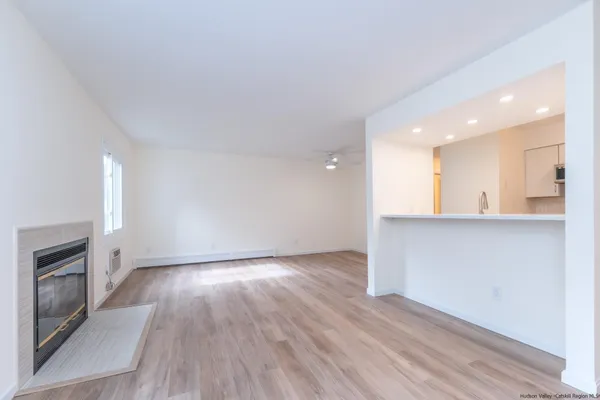 an empty room with wooden floor and fireplace