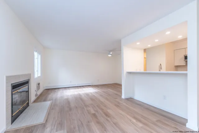 an empty room with wooden floor and fireplace