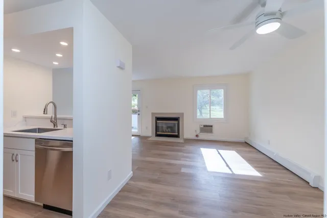 a view of empty room with wooden floor and fireplace
