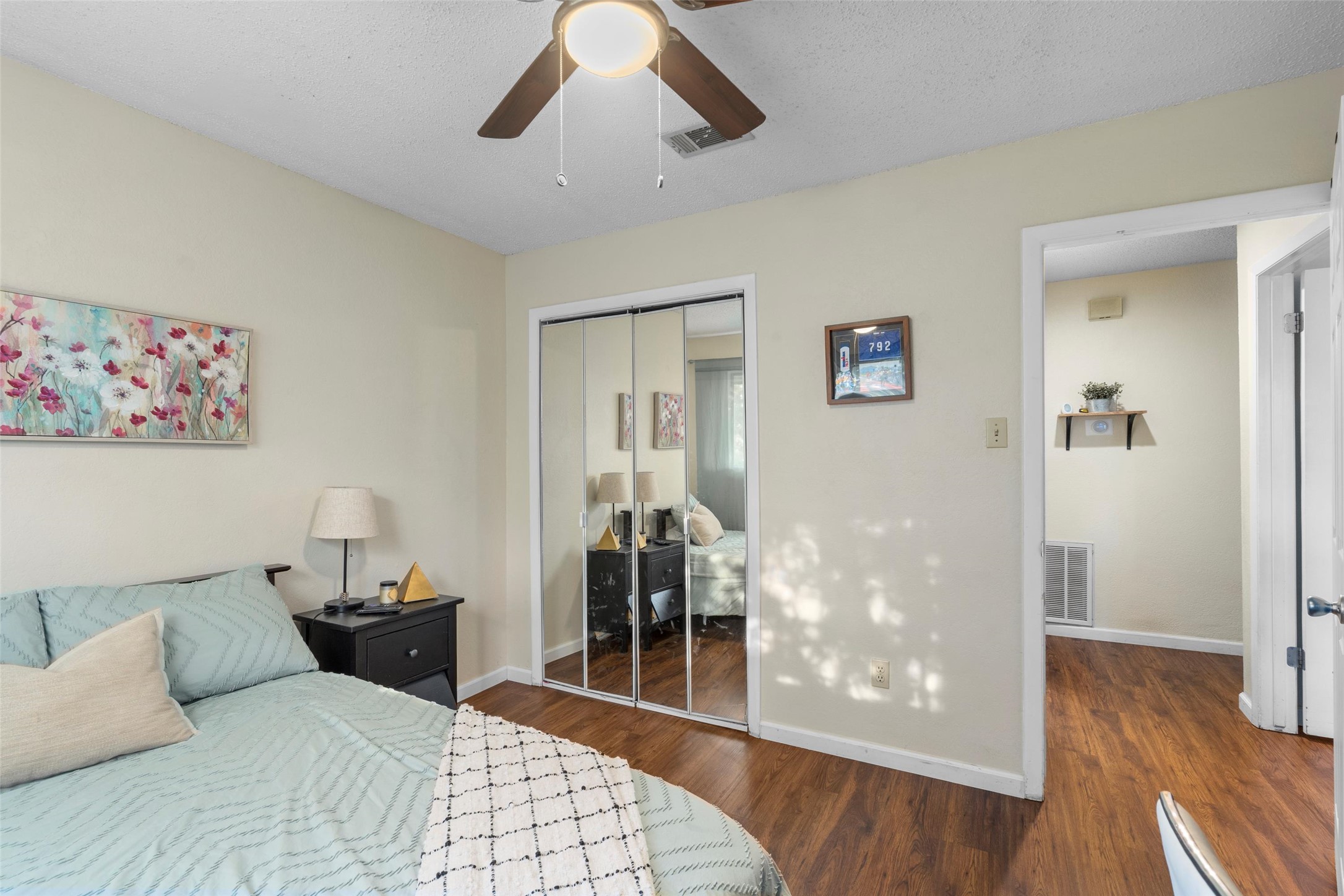 6492 Hart Lane Austin, TX 78731 - Photo 10 of 22 Bedroom featuring wood finished floors, a closet, ceiling fan, and a textured ceiling