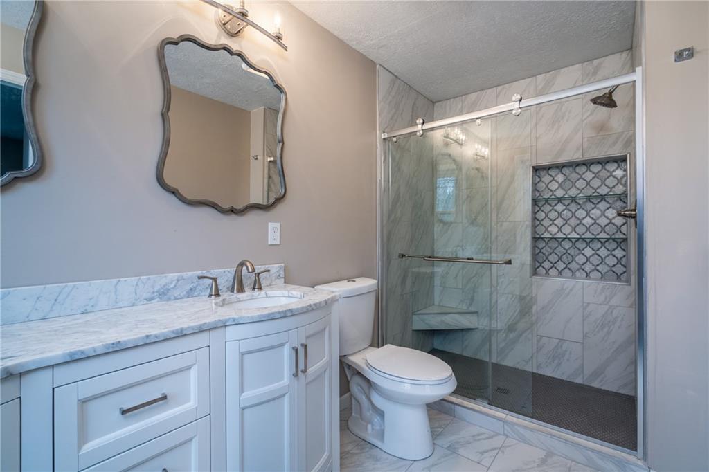 1799 Locust Road Sewickley, PA 15143 - Photo 15 of 25 Luxury main level master suite with double vanity and custom shower with seamless glass enclosure.
