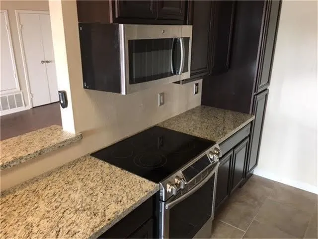 a kitchen with stainless steel appliances granite countertop a stove and a microwave