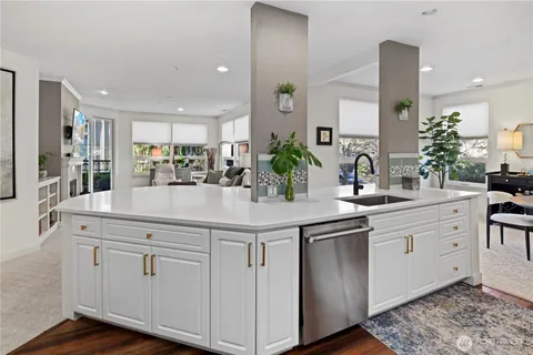 a kitchen with white cabinets sink and stove