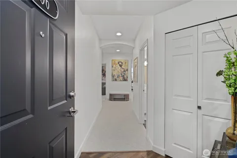 a view of a hallway with wooden floor and closet