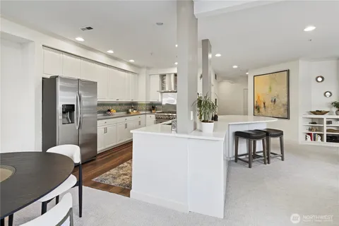 a kitchen with kitchen island a stove a table and chairs in it