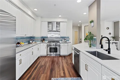 a kitchen with white cabinets stove and sink