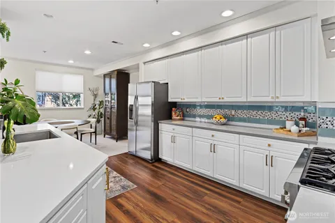 a kitchen with stainless steel appliances sink refrigerator and cabinets