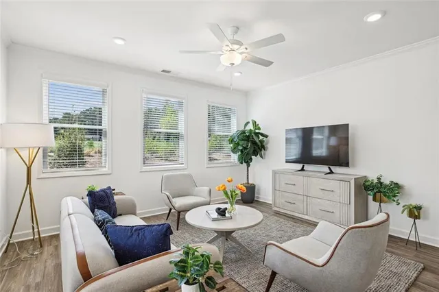 a living room with furniture a flat screen tv and a large window