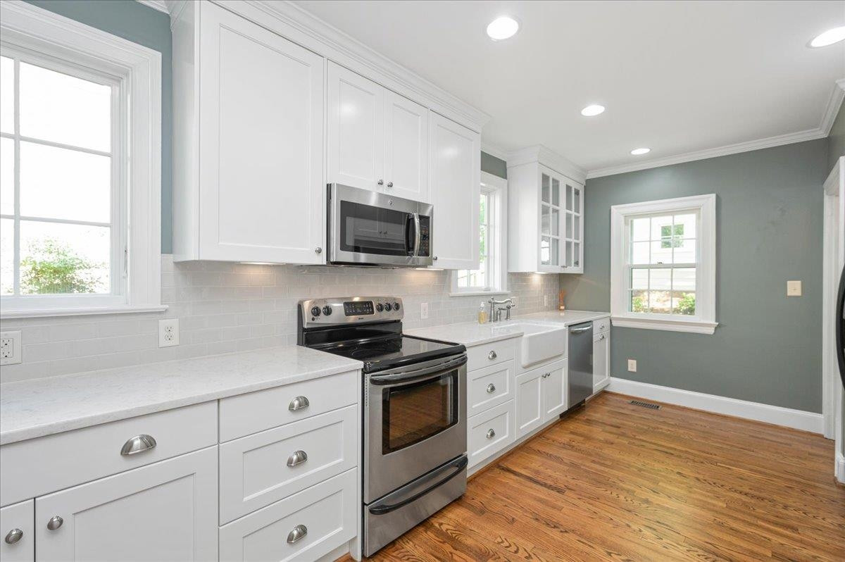 2511 Kenmore Drive Raleigh, NC 27608 - Photo 11 of 34 Stainless steel appliances and farmers apron white sink. Microwave, electric range - Refrigerator and Washer and Dryer included. Washer and Dryer in Kitchen is enclosed cabinet stored - under cabinet lighting Kitchen
